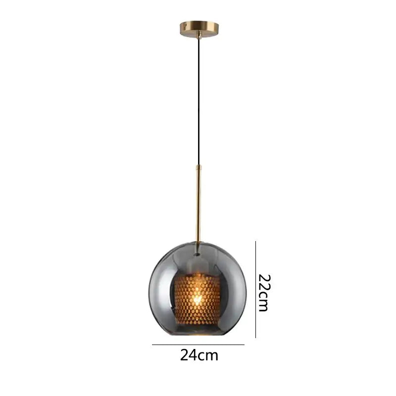 A modern gold honeycomb glass pendant light with a dark smoked glass globe and brass rod for dining room fixtures