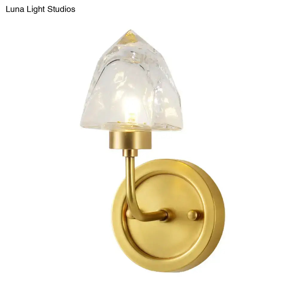 Modern gold ice cube wall light featuring a textured clear glass shade shaped like an inverted pyramid for bedroom use