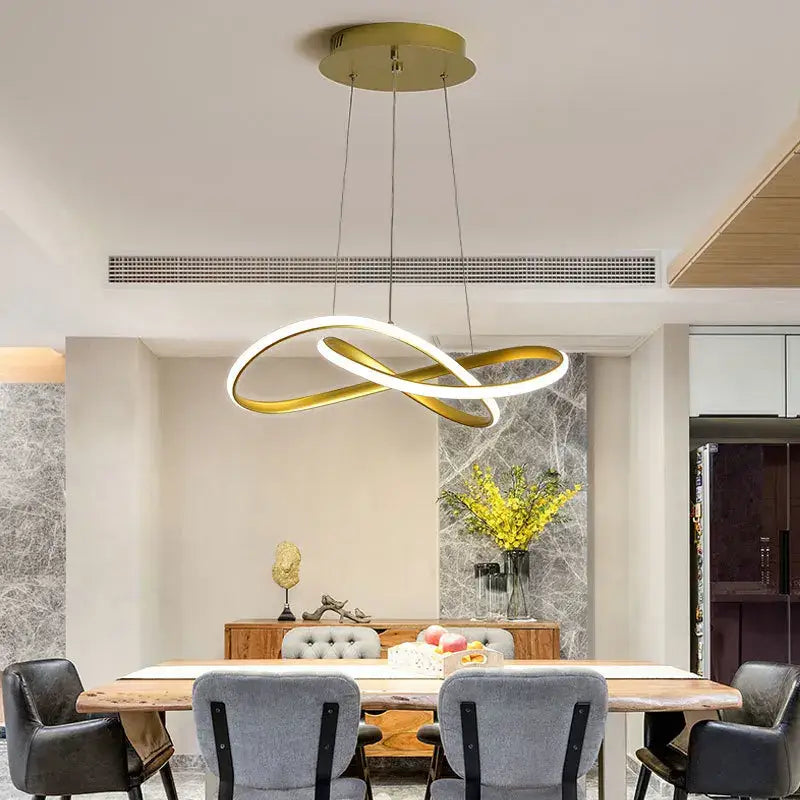 Modern gold infinity loop pendant light with illuminated inner ring and sleek cord pendant design for dining room