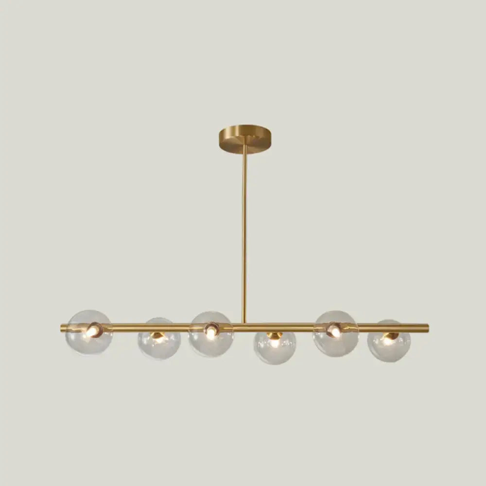 Modern gold island pendant lighting featuring a brass linear design with six clear glass globe bulbs for dining rooms