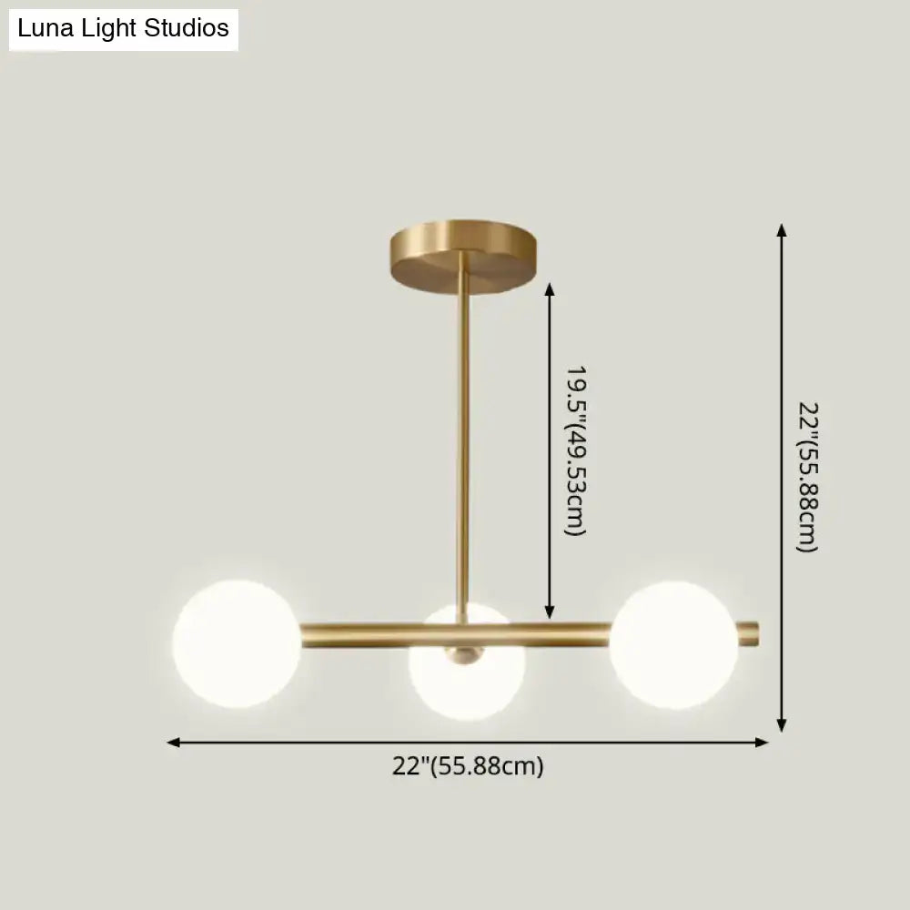 Modern brass island pendant lighting with three spherical white glass globe shades for dining room use
