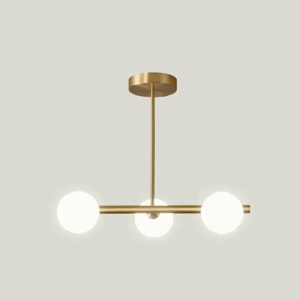 Modern gold island pendant lighting with brass fixture and three frosted glass globe shades for dining room island pendant lighting