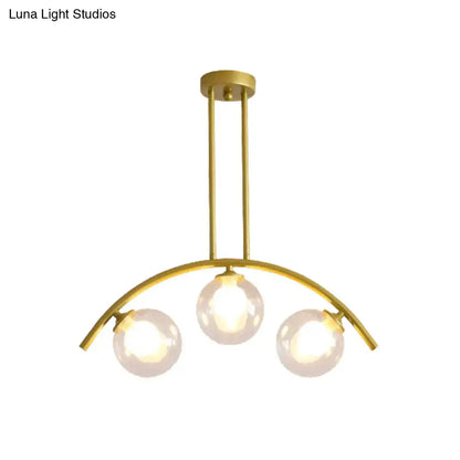 Gold-toned DecorBites island pendant with clear white shade and three spherical glass bulbs for modern kitchens