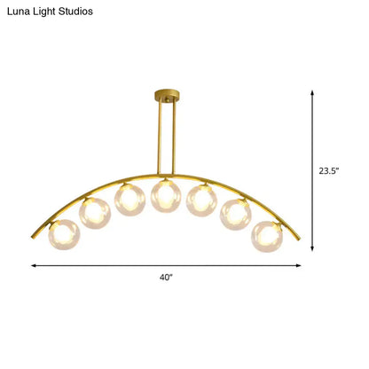 Gold-toned decorbites™ island pendant with clear white shade and six spherical glass bulbs for modern kitchens