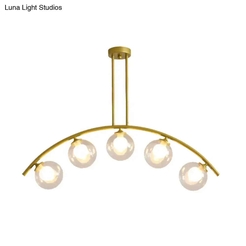 Decorbites gold island pendant with clear white shade features five spherical glass bulbs in a curvy arched design