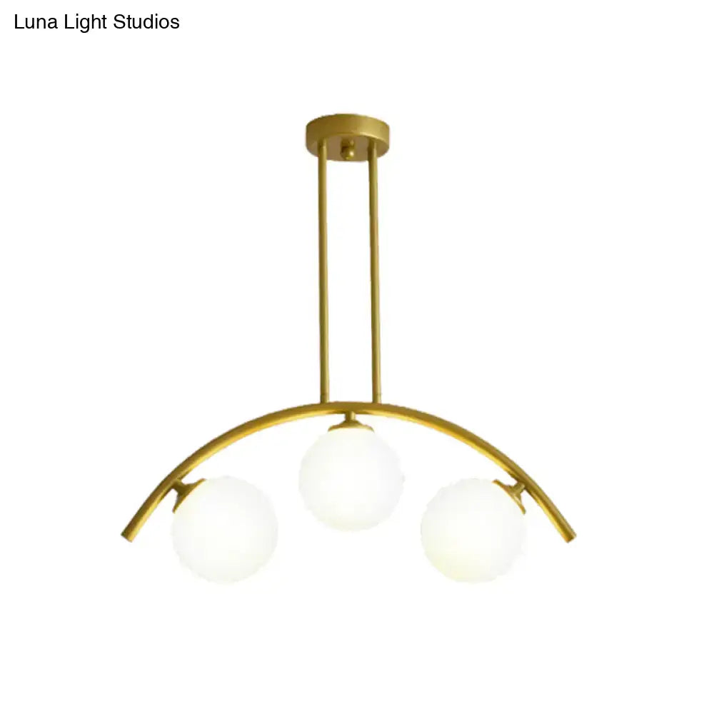 Gold-toned DecorBites island pendant with clear white shade and three frosted glass globes for modern kitchen lighting
