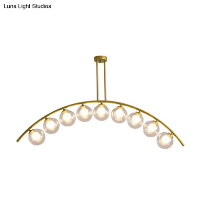 Gold-toned decorbites island pendant with nine spherical glass bulbs and clear white shade for modern kitchens