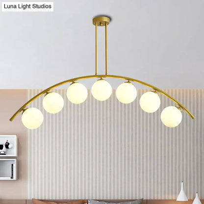 Gold-toned DecorBites island pendant with six spherical frosted bulbs and clear white shade for modern kitchens