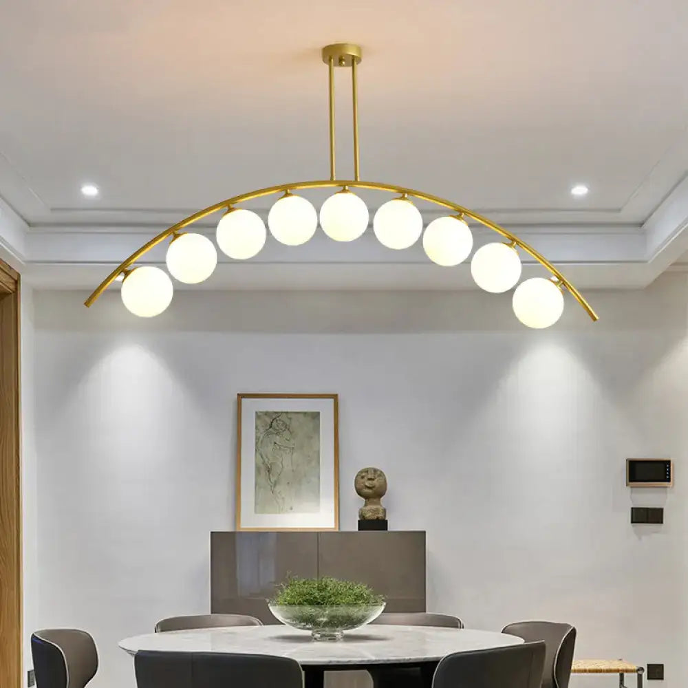 Decorbites gold island pendant with clear white shade featuring gold-toned arch and spherical frosted glass bulbs