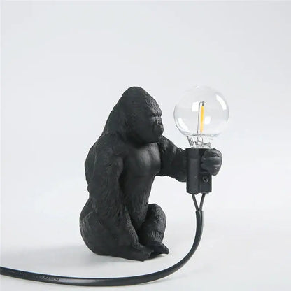 Black gorilla-shaped king kong resin night light with textured matte finish holding clear glass bulb for decorbites decor