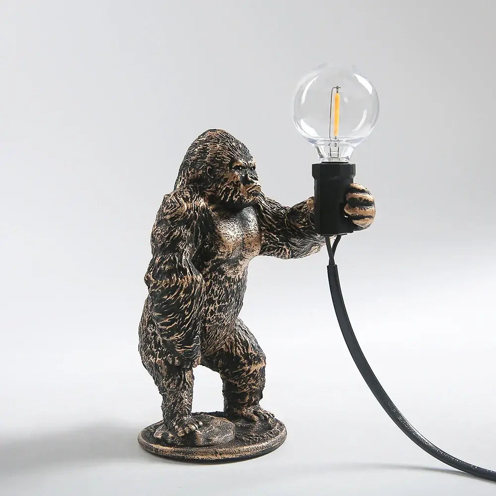 Modern gold king kong resin night light featuring a bronze-finished gorilla figurine lamp holding a clear glass bulb