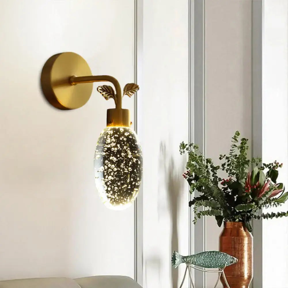 Modern gold leaf led wall sconce with seeded crystal globe and leafy metal accents for bedroom lighting