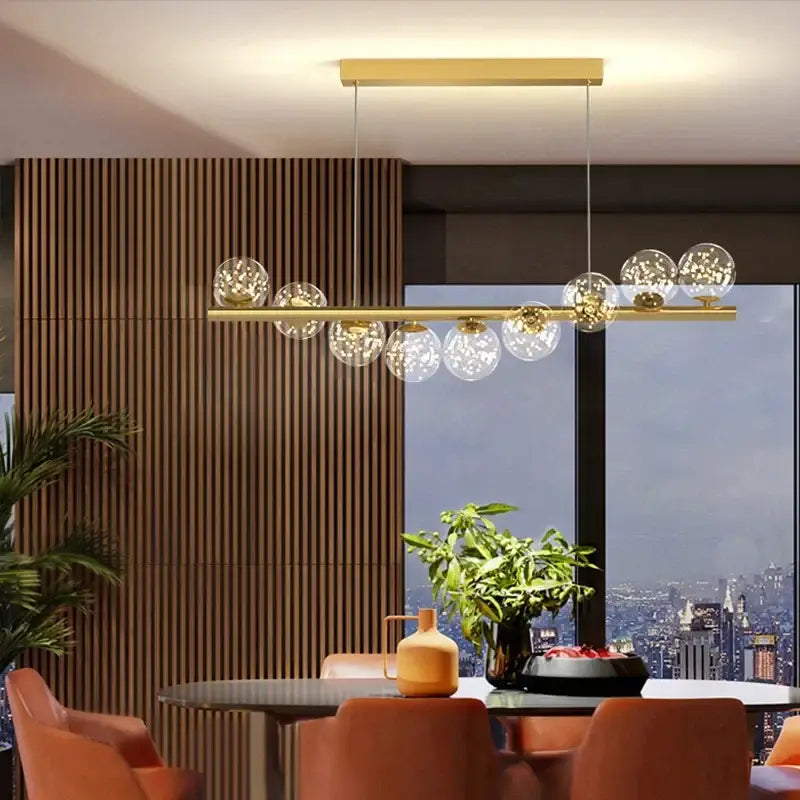 Modern gold led ceiling chandeliers with clear glass globe bulbs suspended from a sleek horizontal bar for dining room use