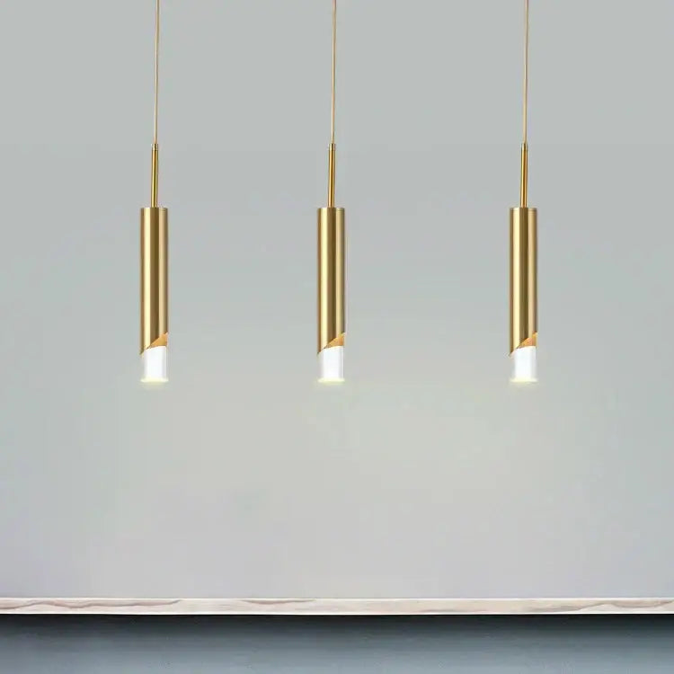 Three sleek gold led pendant lights by decorbites with cylindrical design hang in a modern dining room decor