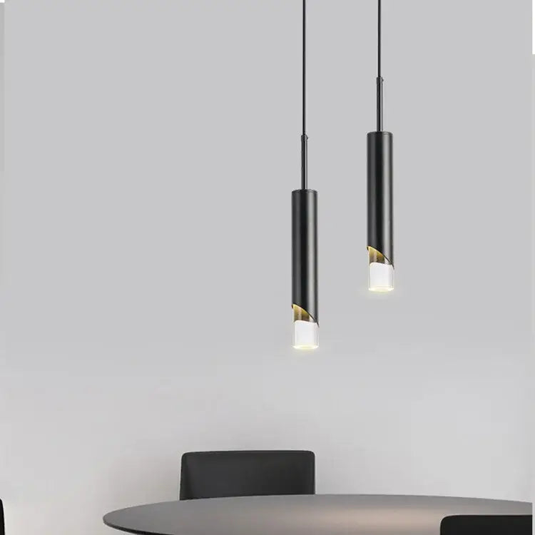 Two black cylindrical pendant lights with gold led cutouts hang as modern gold led pendant decorbites pendant light