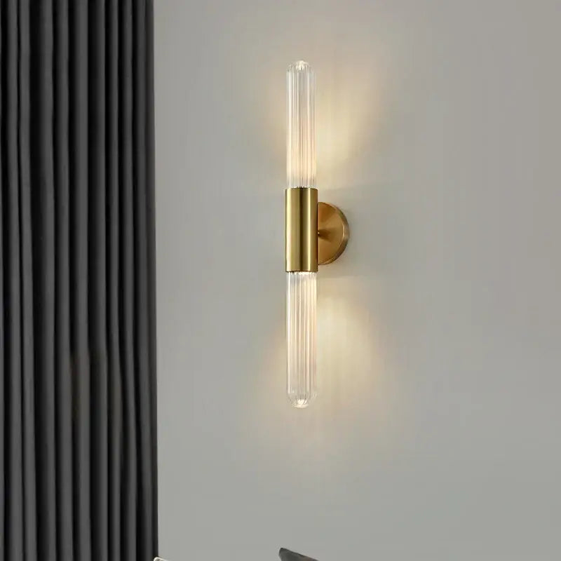 Modern gold led sconce with clear white glass and sleek gold metal base for bedroom wall lighting