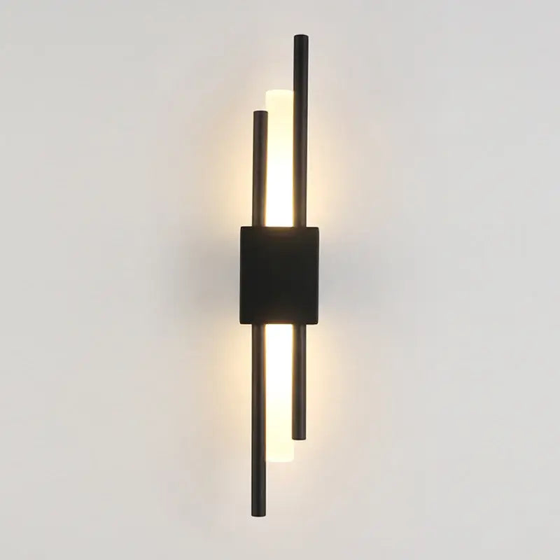 Modern black led wall sconce with three vertical rods and central square fixture providing warm bedroom ambient lighting