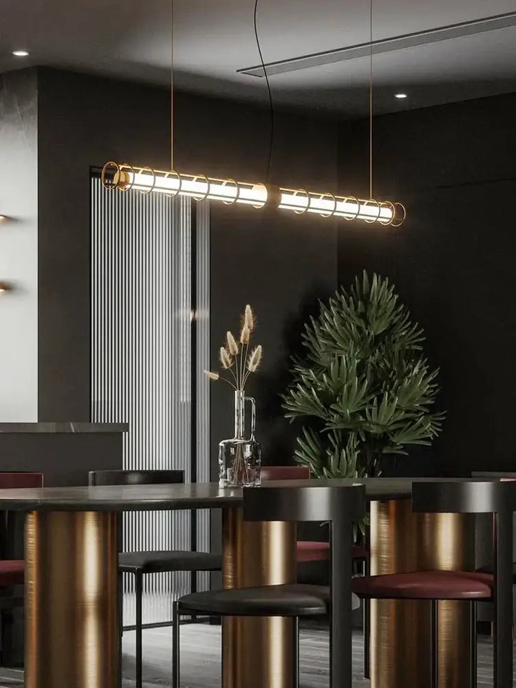 Modern gold linear glass dining room chandelier pendant light with sleek cylindrical design and warm golden glow decorbites glass dining