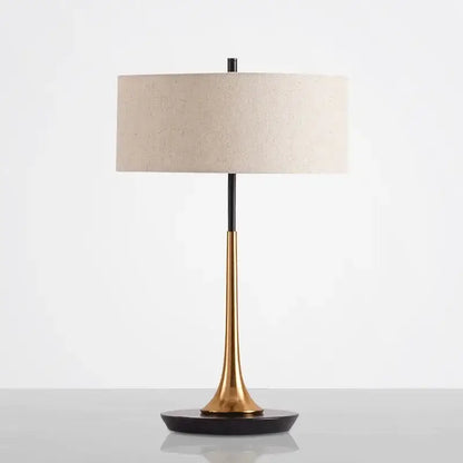 Modern gold luxury led table lamp with sleek two-toned brass and black metal base and off-white linen shade for decorbites gold luxury decor
