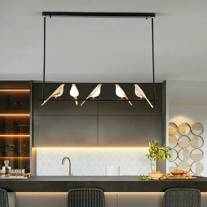 Modern black metal pendant light with four stylized white magpie bird bodies and gold-toned beaks for decorbites gold magpie ceiling decor