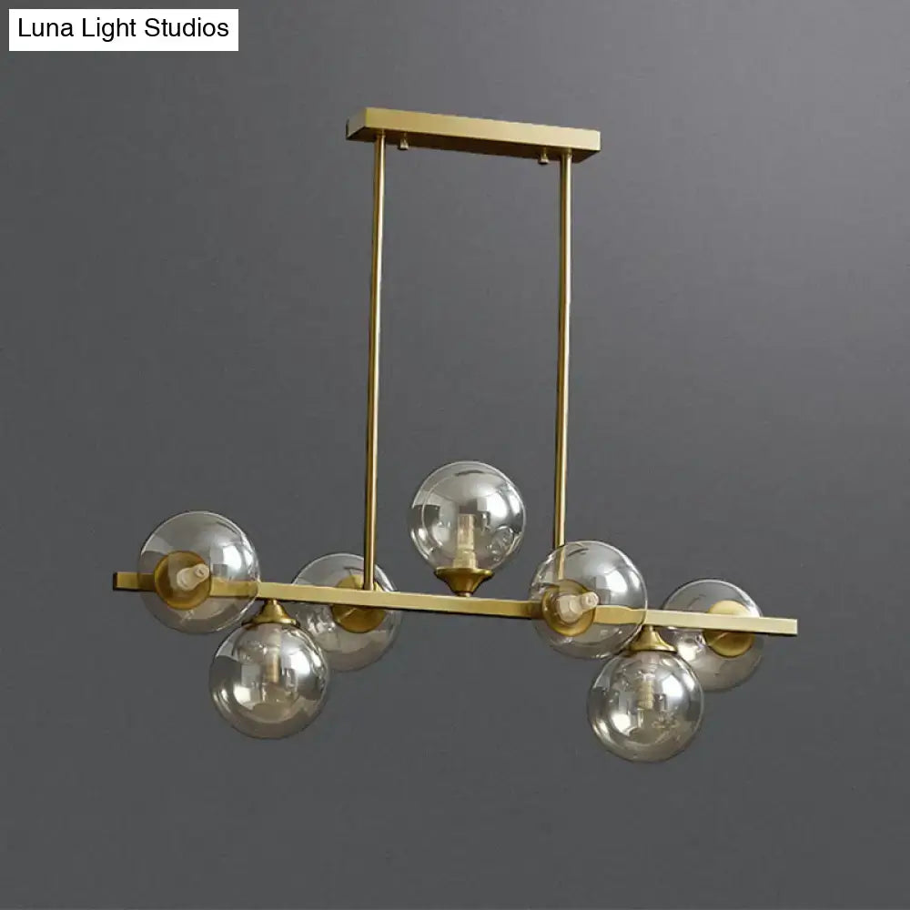 Modern gold metal chandelier with five spherical amber glass bulbs for dining room island lighting