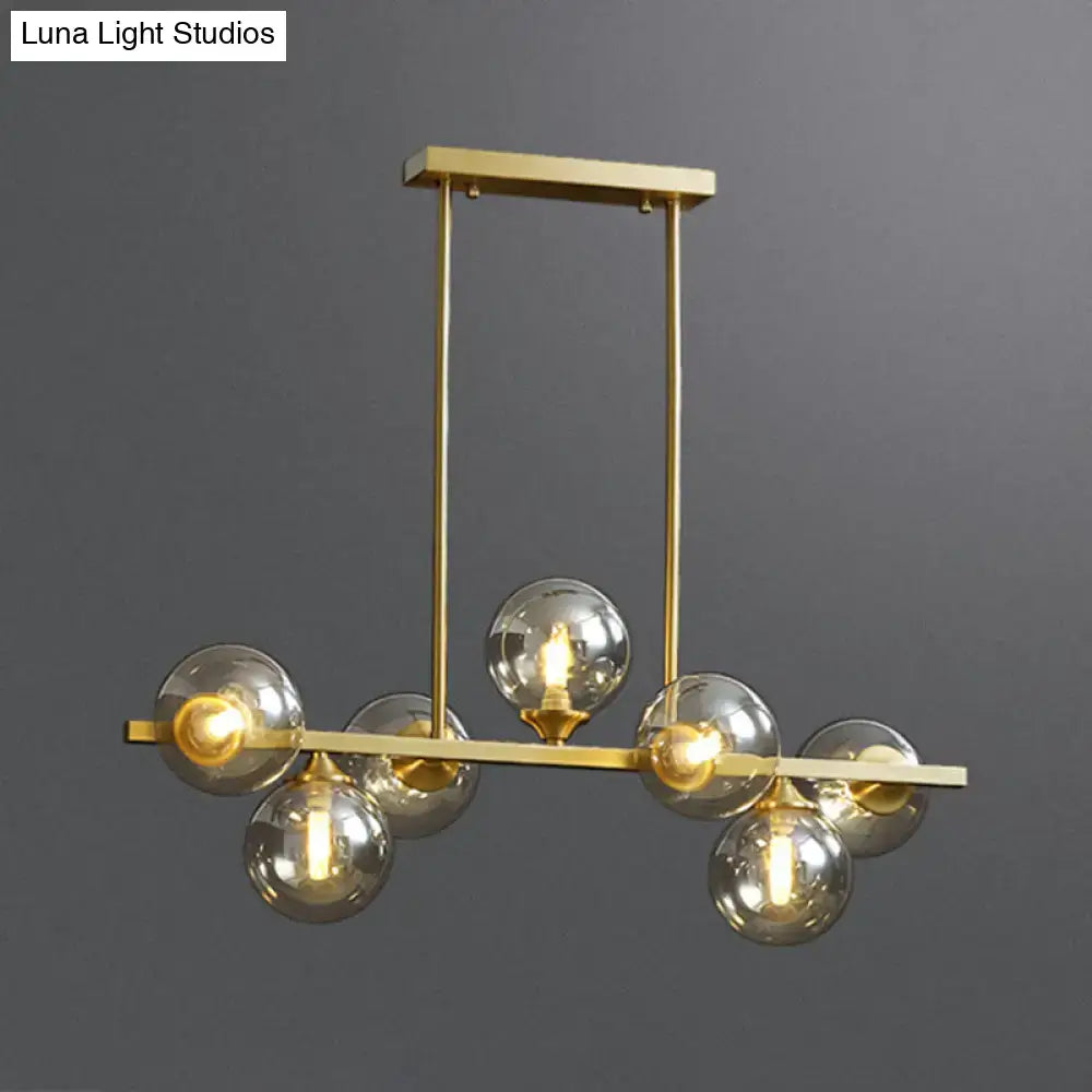 Modern gold metal chandelier with six spherical amber glass bulbs for dining room island lighting