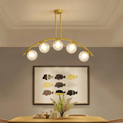 Modern gold metal arched ceiling light with five clear glass globe bulbs for dining room illumination