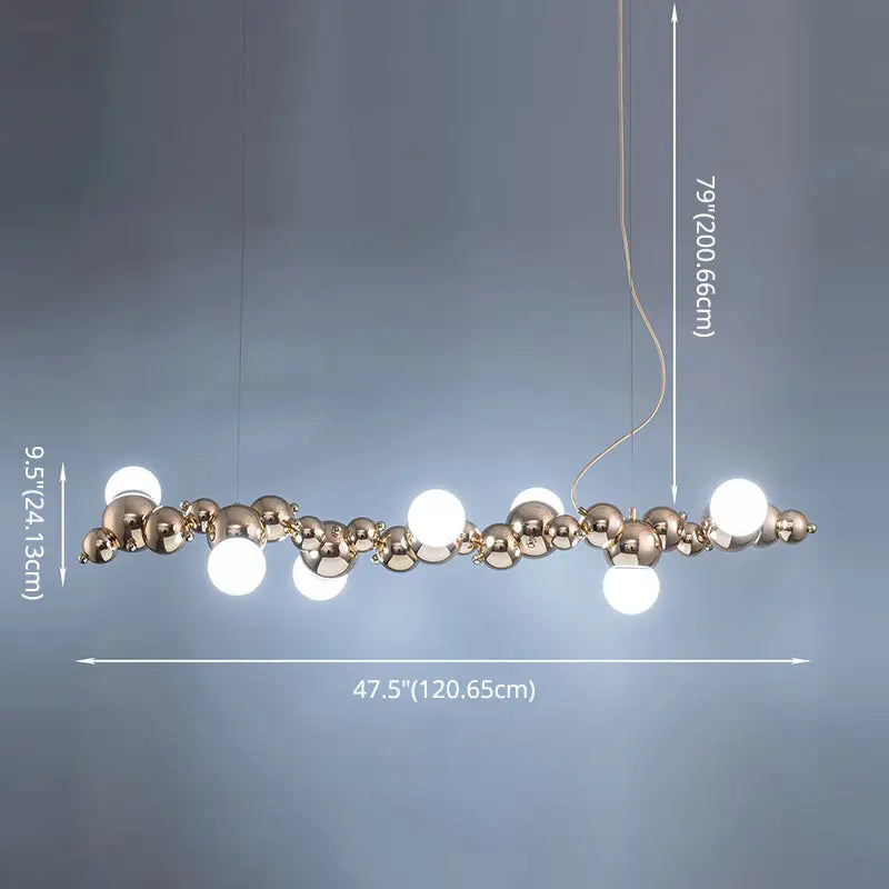 A modern gold metal arched ceiling light with six bulbs featuring polished brass spheres for dining room use