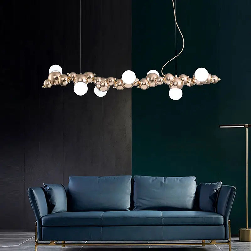 Modern gold metal arched ceiling light with six bulbs featuring polished gold spheres and white frosted globes for dining room