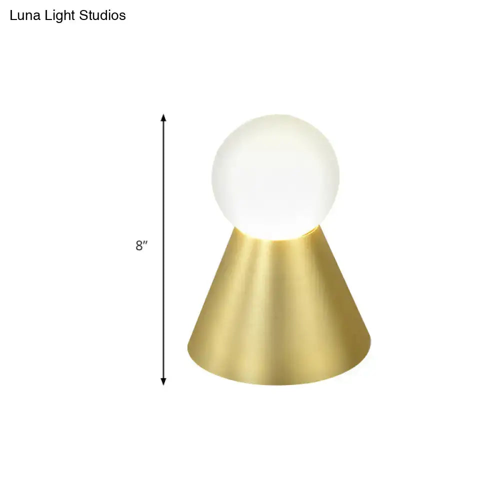 A sleek 8-inch metal conical sconce wall light with brushed brass base and frosted white globe shade for bedroom use