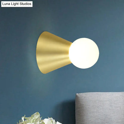 Modern gold metal conical sconce wall light with frosted globe bulb ideal for bedroom lighting