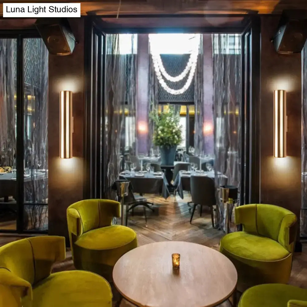 Vibrant lime green velvet armchairs with rounded backs complement a modern gold metal fixture wall lamp for corridor use