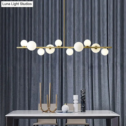 Modern gold metal glass globe chandelier with frosted glass bulbs and adjustable chain cord length for dining table lighting