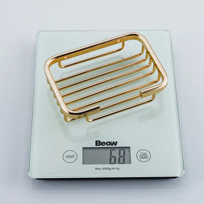 Modern gold metal glass soap dish with sleek horizontal bars and rounded edges for bathroom wall mounting
