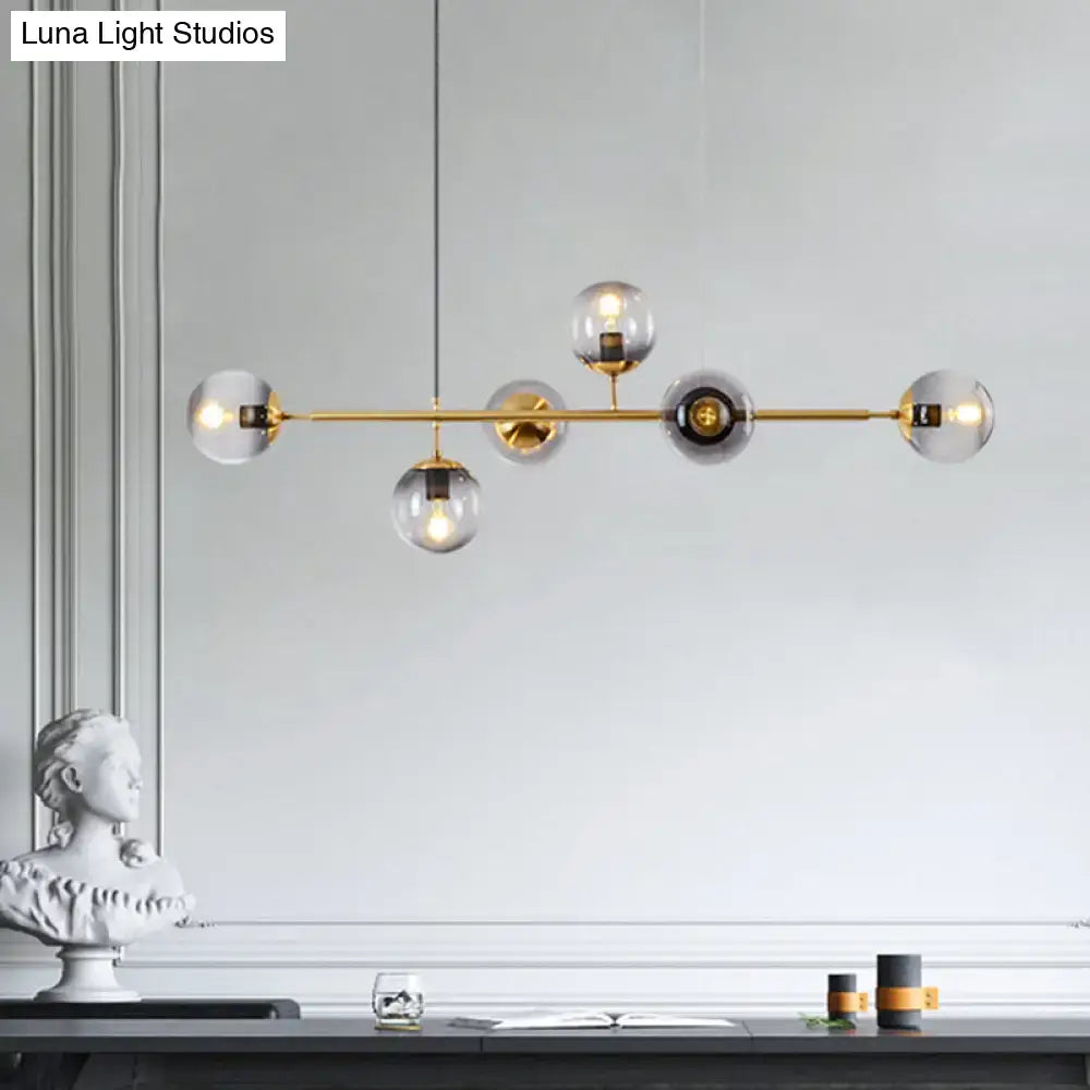 Modern gold metal island pendant with brass bar and clear smoky glass globe bulbs for dining room lighting