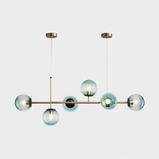 Modern gold metal island pendant with six translucent blue glass spheres suspended from brass ceiling fixtures