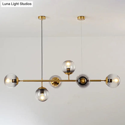 Modern gold metal island pendant with clear glass globe bulbs and blue spheres for dining room lighting
