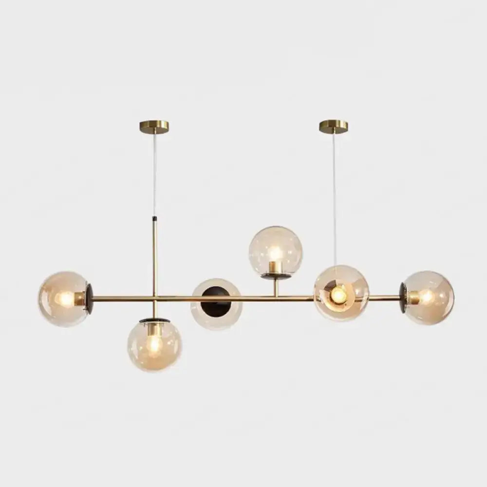 Modern gold metal island pendant with five blue glass spheres and minimalist design for dining room lighting