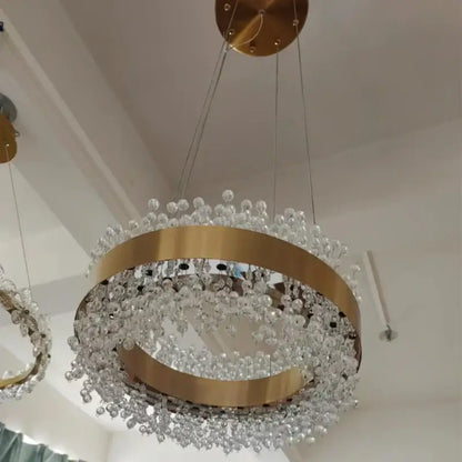 A modern gold metal led chandelier with circular frame and cascading clear crystal beads for dining room decorbites gold metal