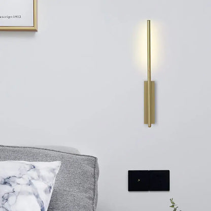 Modern gold metal linear wall light with sleek vertical design and warm ambient lighting for bedroom use