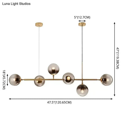 Modern gold metal pendant lighting featuring brass and smoked glass globes in a sleek minimalist design for dining rooms