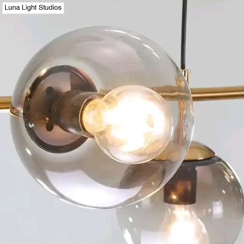 A warm-toned frosted glass globe pendant lighting with modern gold metal fixture and exposed edison bulb for dining room