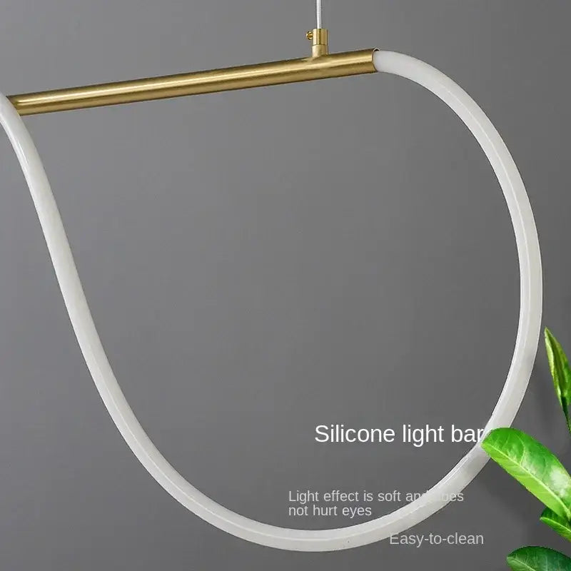 A sleek curved white silicone pendant light with gold minimalist led metal fixture for modern kitchen decorbites
