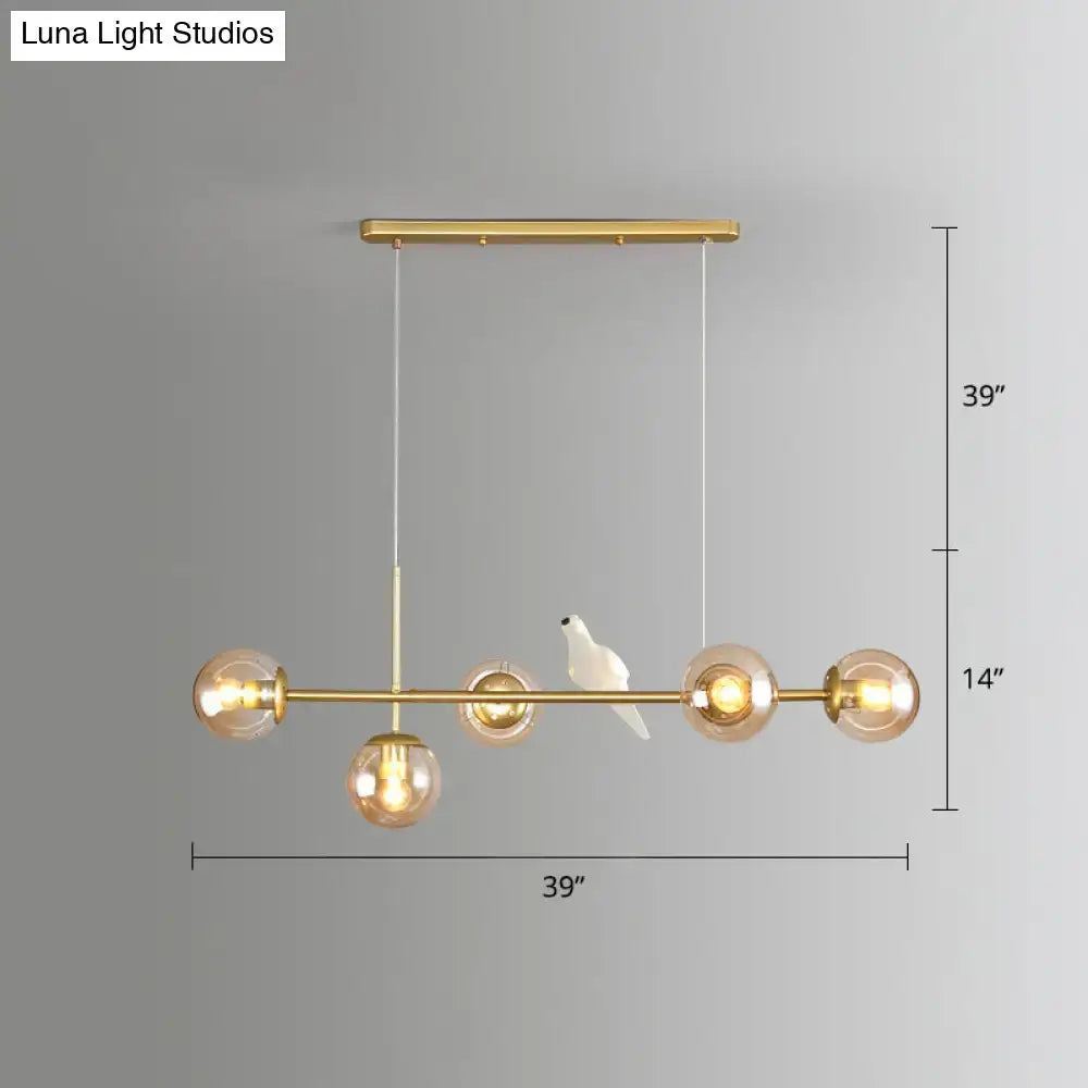Modo island gold pendant light with five spherical milk white glass bulbs and white ceramic bird for restaurants