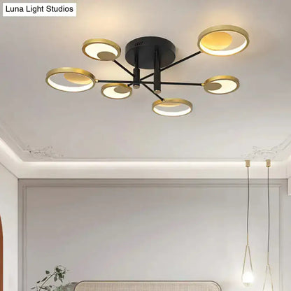 Modern gold molecule ceiling mount chandelier with black base and six illuminated gold-toned circular rings