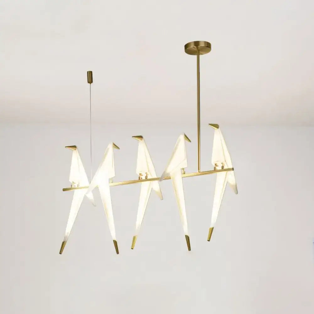 Modern gold origami bird pendant light featuring five illuminated translucent white birds with metallic beaks for dining room decor