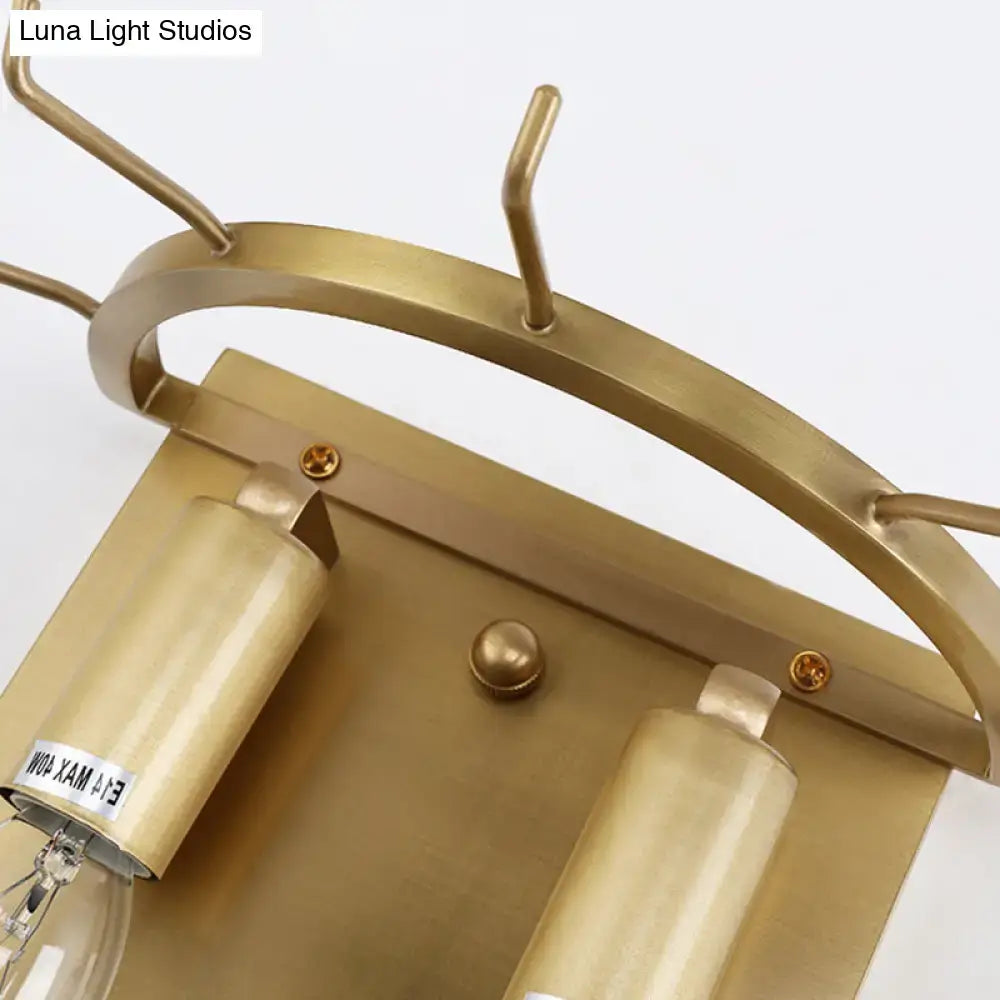 Modern gold oval sconce light with brass-finished curved frame and two cylindrical fixtures for living room wall