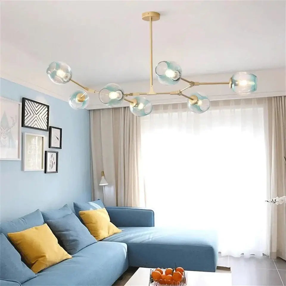 Modern gold painted metal pendant light with translucent light blue glass globe shades for dining room use