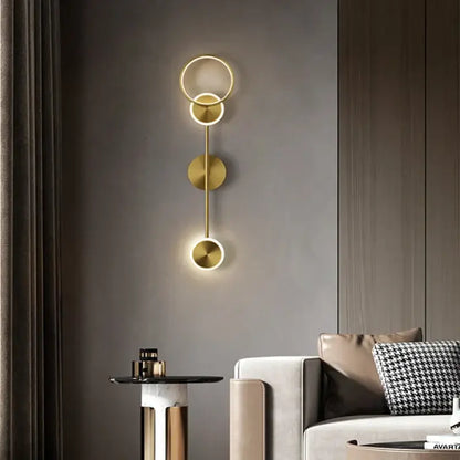 Modern gold plated three disc led wall lamp with gold toned rings emitting warm glow for bedroom decorbites gold plated