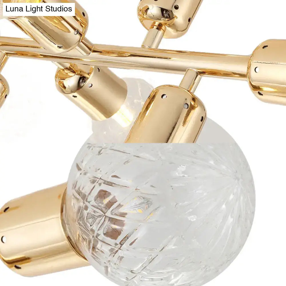 Gold finished metal arms support a prismatic glass ceiling light with clear faceted globes and bulb base sockets